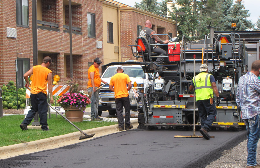 Construction Workers Smoothing out Asphalt