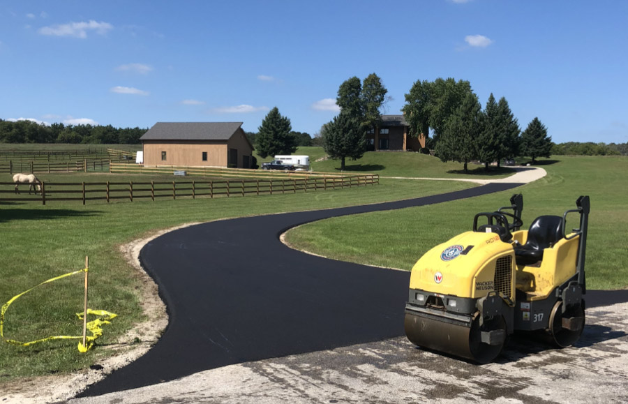 Roller and new asphalt residential driveway