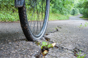 Bike tire on a paved road with cracks